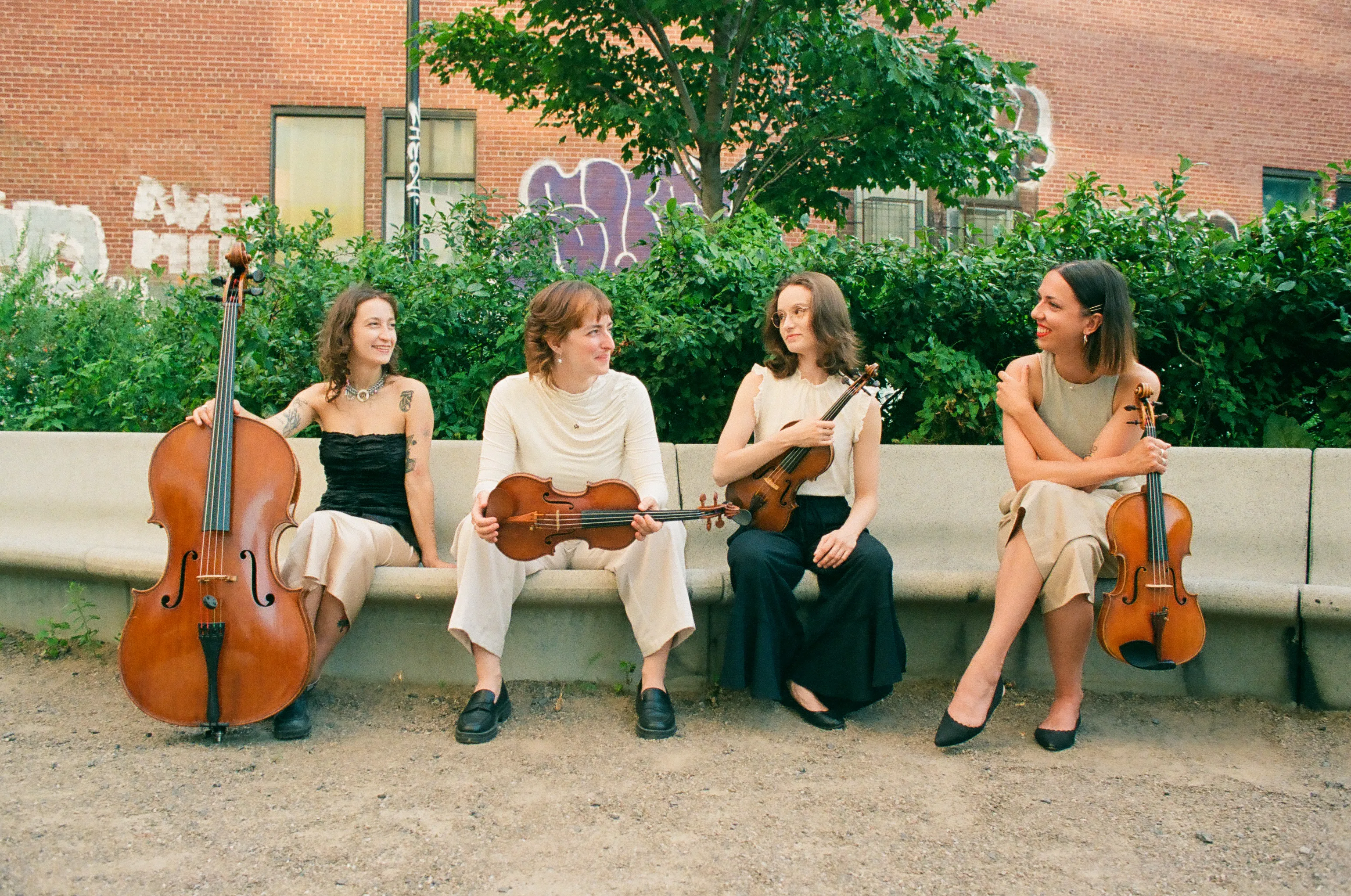 All members of the band sitting on a concrete bench.