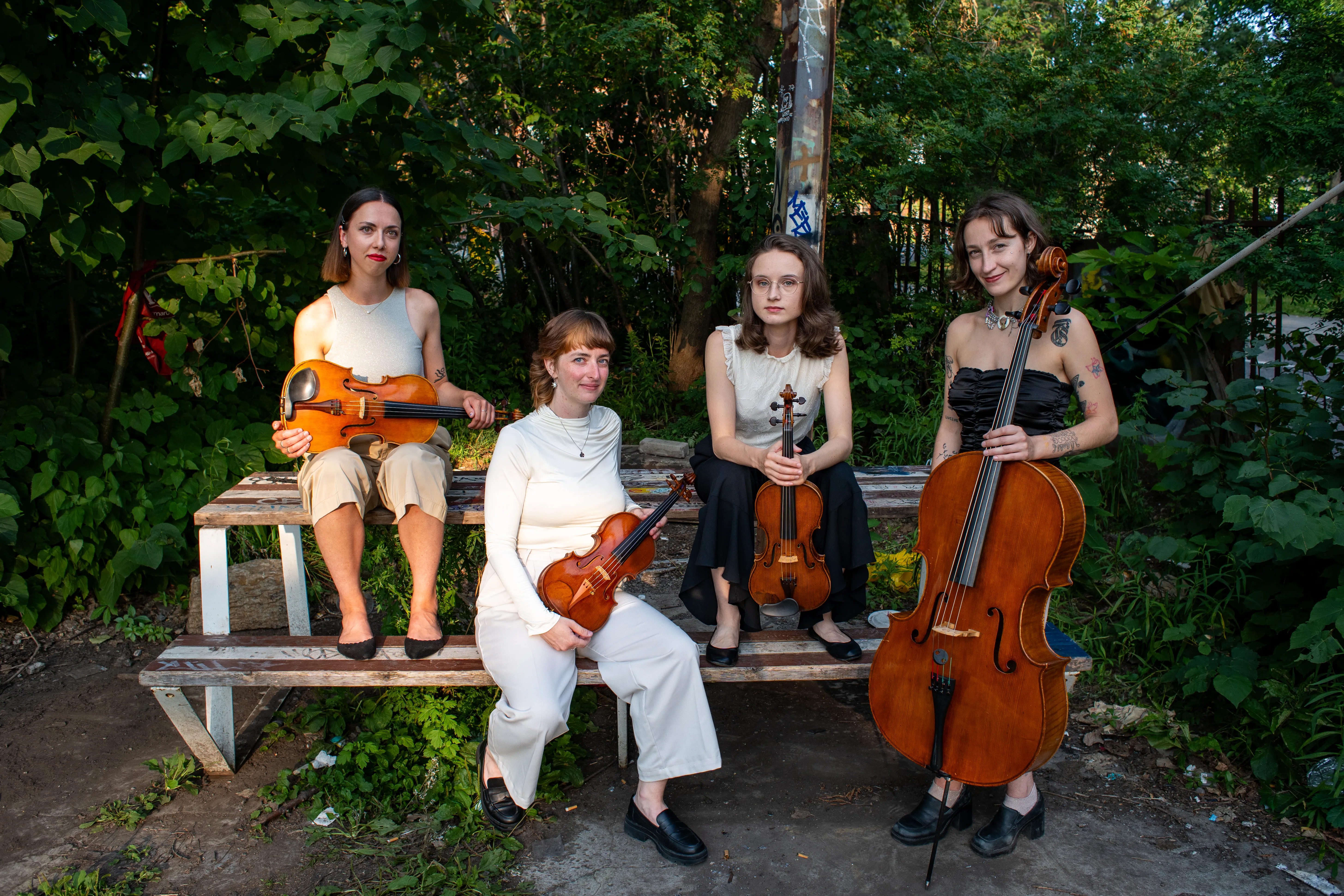 All members of the band posing in front of a picnic table.