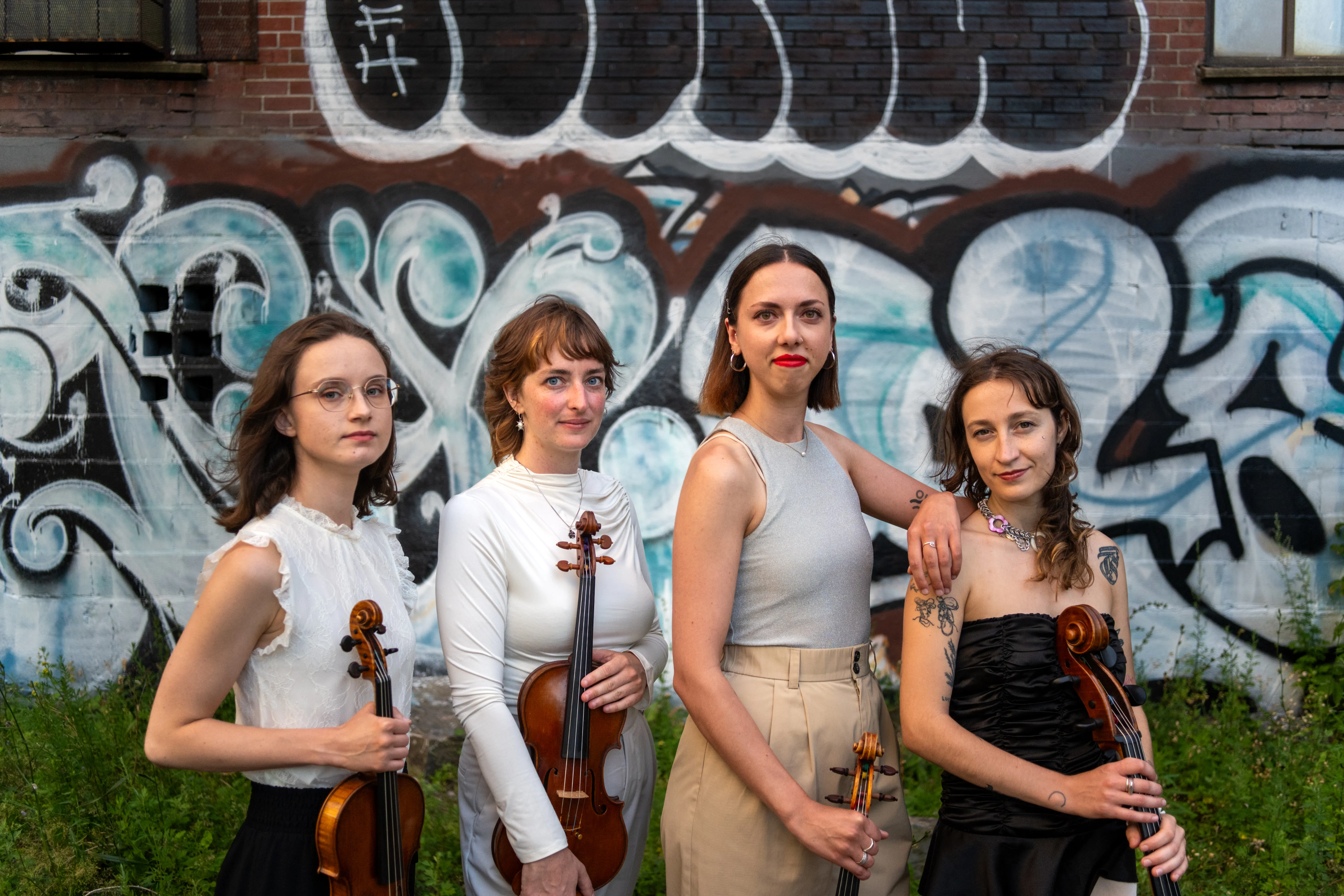 Photo of all members of the band posing in front of a building.